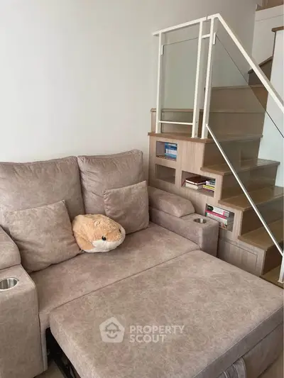 Cozy living room with plush sofa and modern staircase design