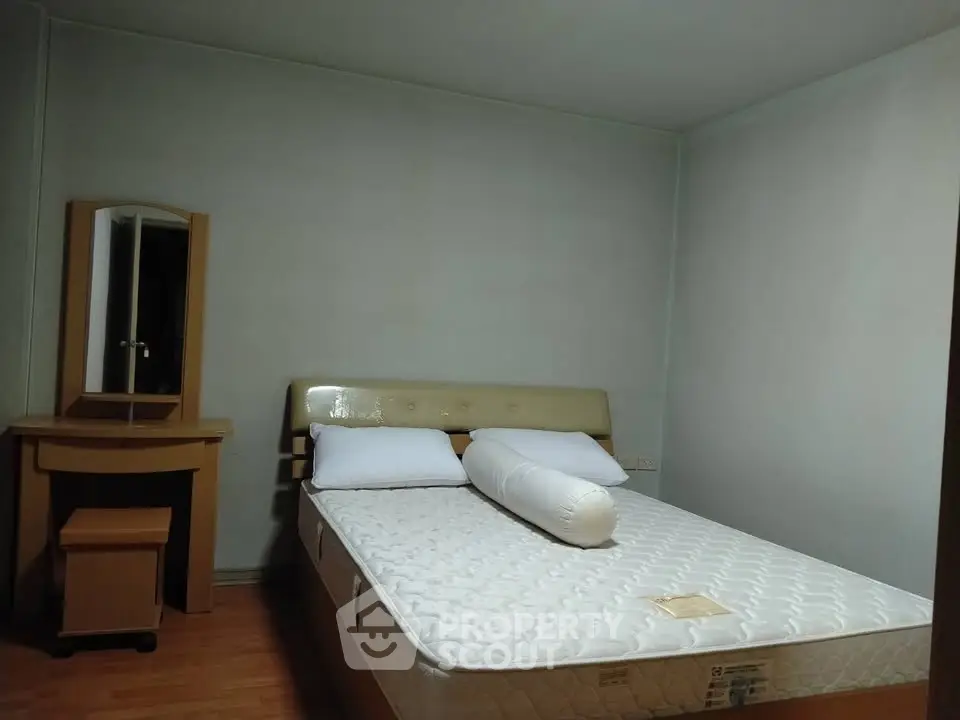 Cozy bedroom with a comfortable bed and wooden furniture, perfect for relaxation.