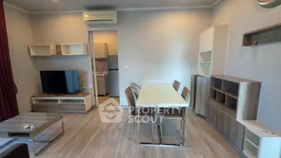 Modern living room with dining area and TV, featuring sleek furniture and neutral tones.