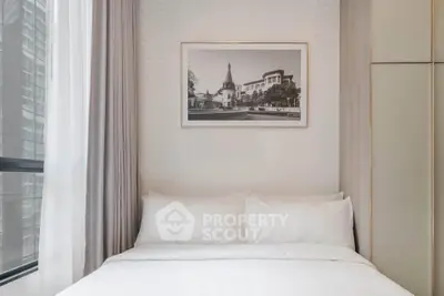Cozy bedroom with modern decor and large window offering city views.
