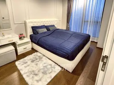 Luxurious bedroom with plush bed and elegant decor, featuring hardwood floors and natural light.