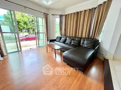 Spacious living room with large windows and stylish leather sofa