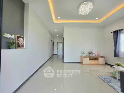 Spacious modern living room with elegant chandelier and sleek tile flooring