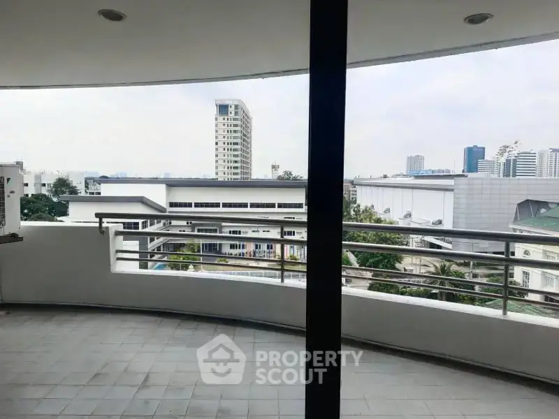 Spacious balcony with city view in modern apartment building