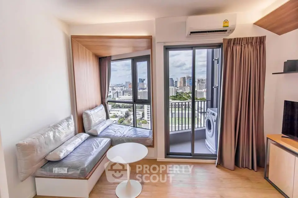 Modern living room with city view and balcony access in high-rise apartment