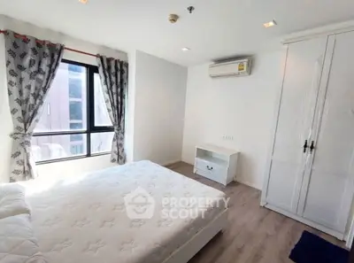 Bright and airy bedroom with modern furnishings and large window view.