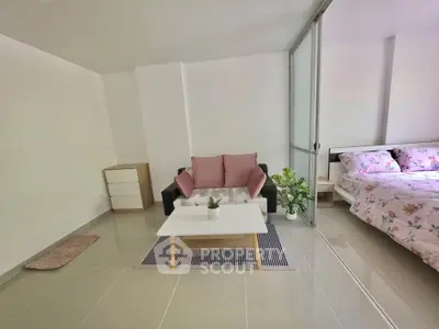 Modern studio apartment with cozy living area and stylish bedroom, featuring sleek tile flooring and elegant decor.