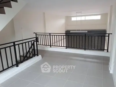 Spacious modern loft with sleek railing and ample natural light, perfect for urban living.