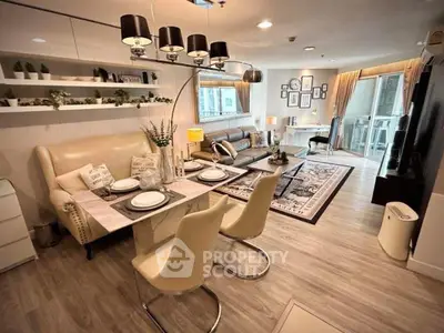 Stylish modern living room with dining area and balcony access, featuring elegant decor and ample natural light.