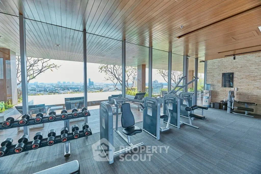 Luxurious gym with panoramic city views and modern fitness equipment.
