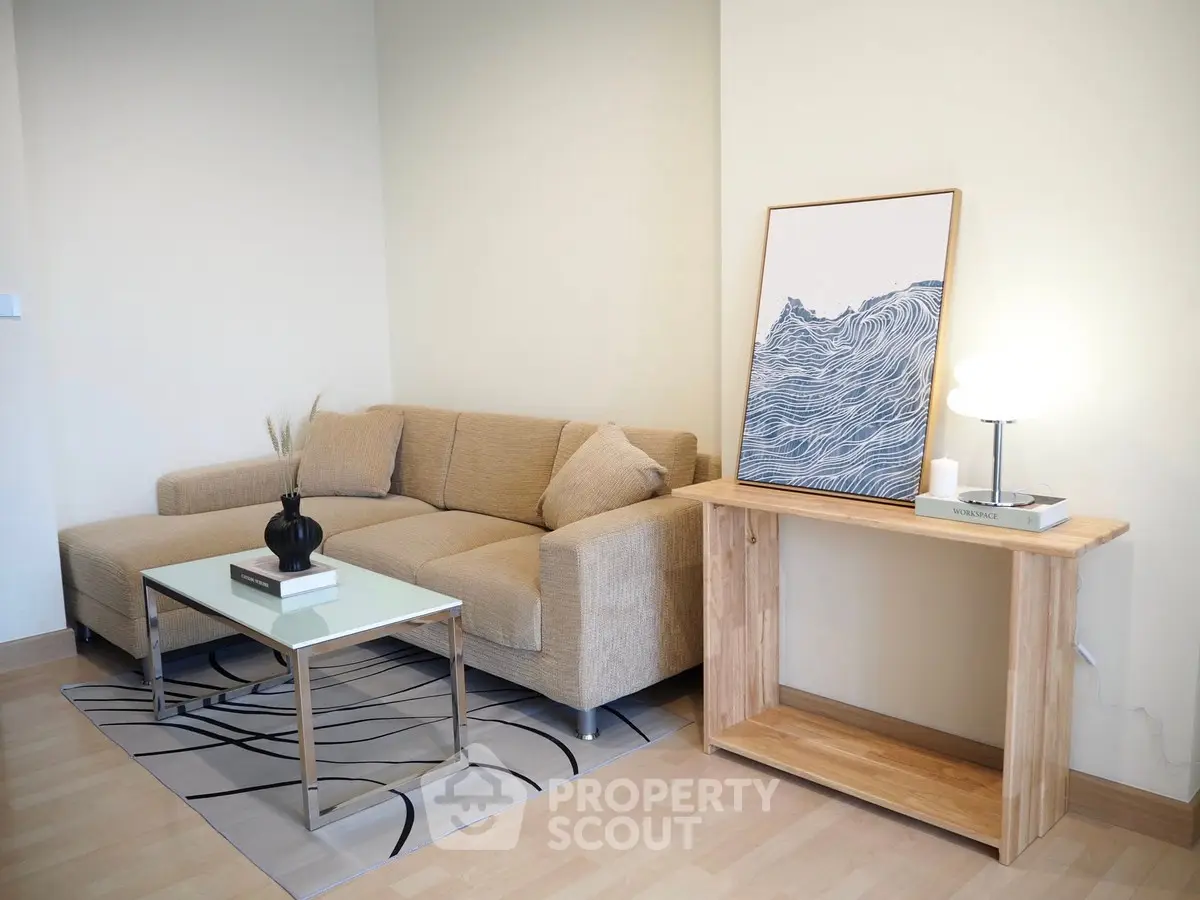 Modern living room with stylish beige sofa and artistic wave painting, perfect for cozy relaxation.