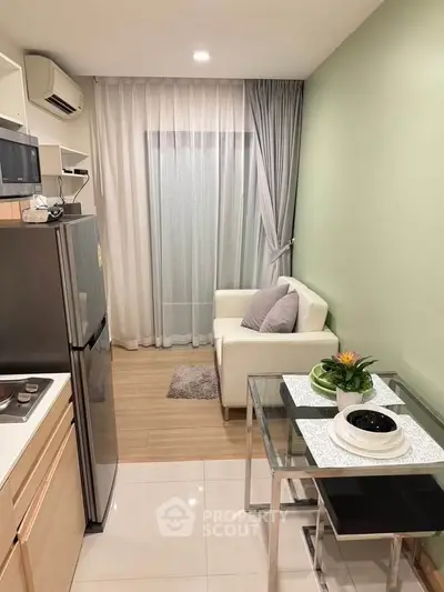 Modern compact living room with kitchenette, featuring sleek design and cozy ambiance.