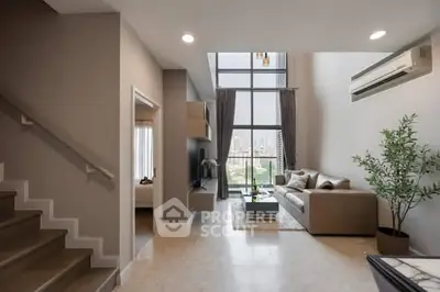 Spacious modern living room with high ceiling and city view, featuring elegant decor and natural light.