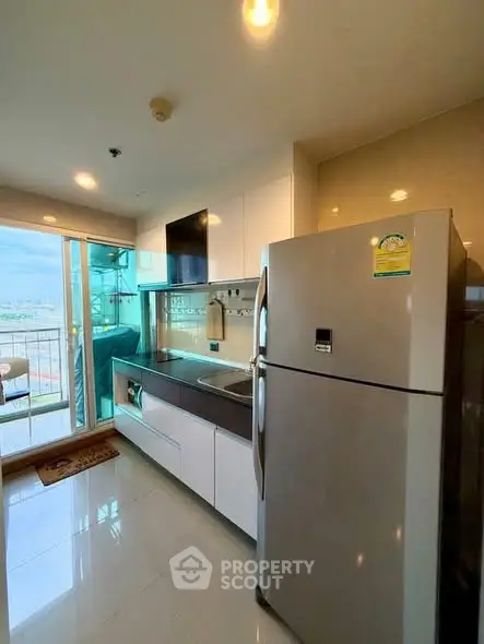 Modern kitchen with stainless steel appliances and balcony view