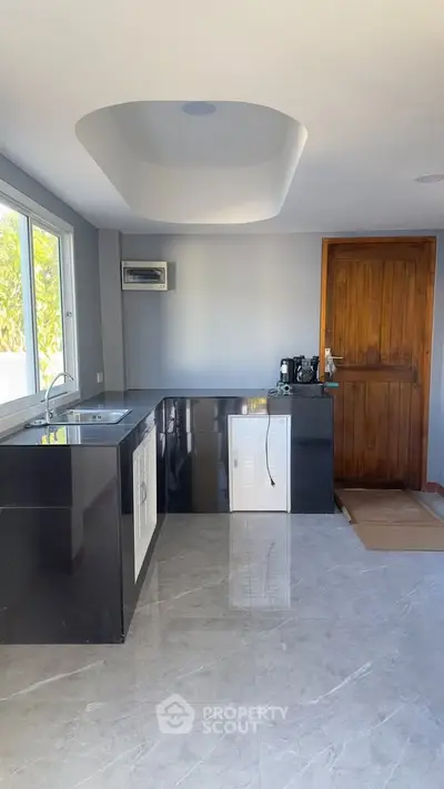 Modern kitchen with sleek black countertops and large window