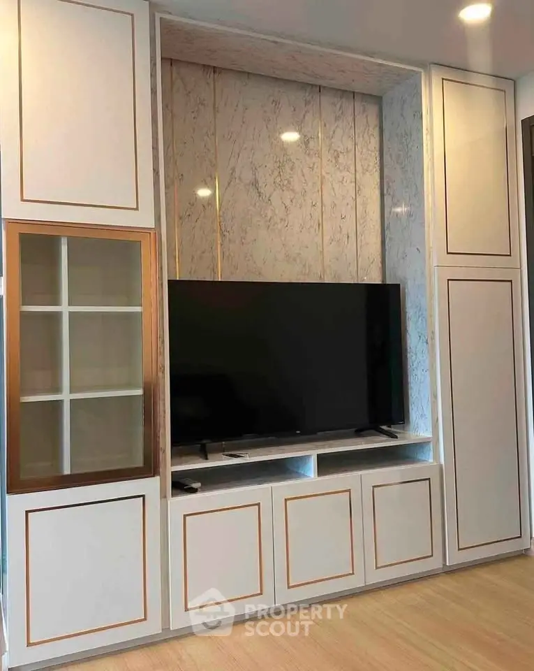 Modern living room with built-in TV cabinet and elegant marble accents.