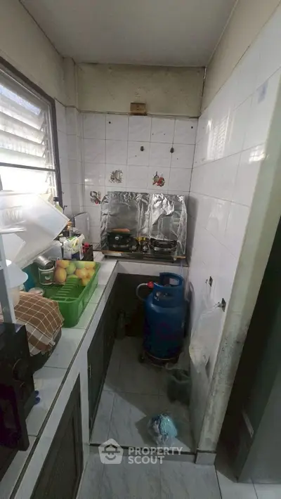 Compact kitchen with gas stove and tiled walls, ideal for small apartments.