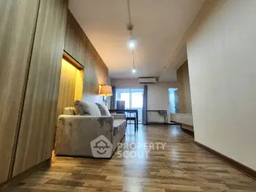 Spacious living room with modern wooden flooring and cozy seating area.