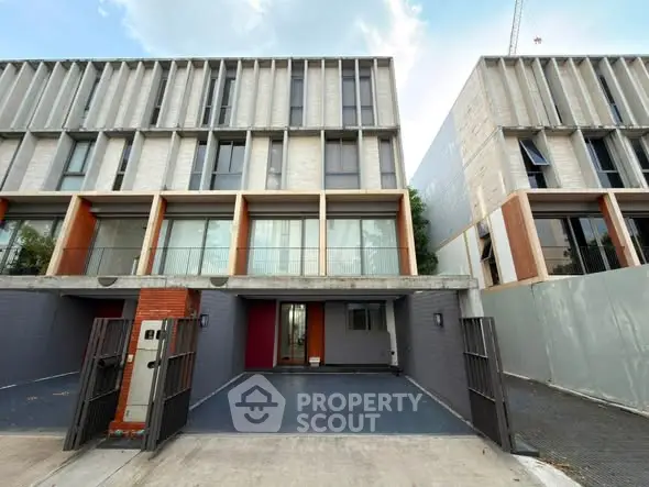 Modern townhouse exterior with sleek design and spacious garage in urban setting.
