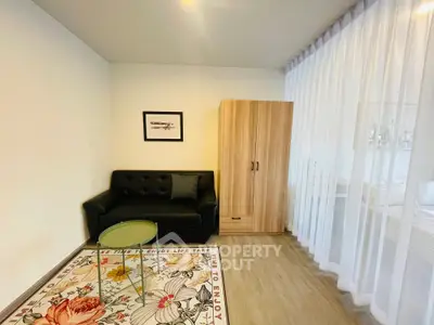 Cozy living room with modern sofa, stylish rug, and elegant wardrobe in a bright, airy space.