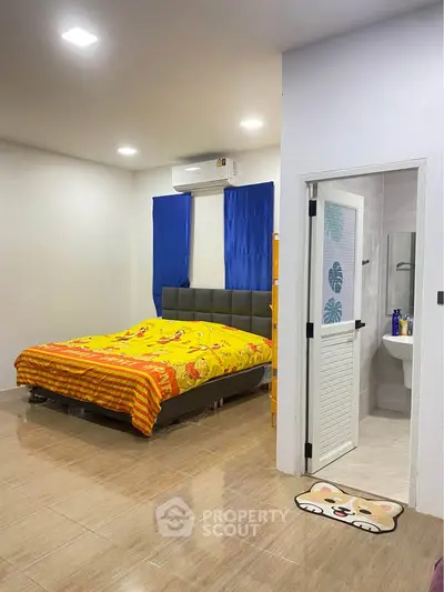 Cozy bedroom with ensuite bathroom, featuring bright decor and modern furnishings, perfect for comfortable living.