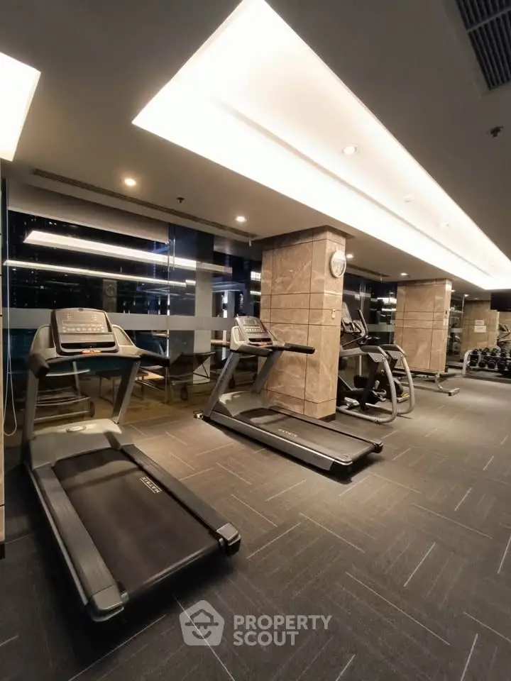 Modern gym with state-of-the-art treadmills and fitness equipment in a luxurious building.