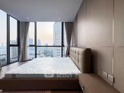 Luxurious bedroom with stunning city view and modern furnishings in high-rise apartment.