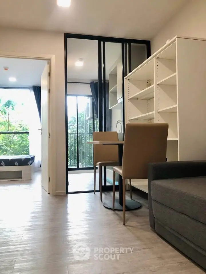 Modern apartment interior with open layout, featuring a cozy living area and a view of the balcony.