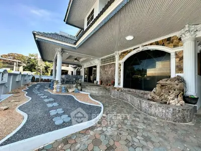 Stunning exterior of luxury home with unique stone pathway and elegant columns