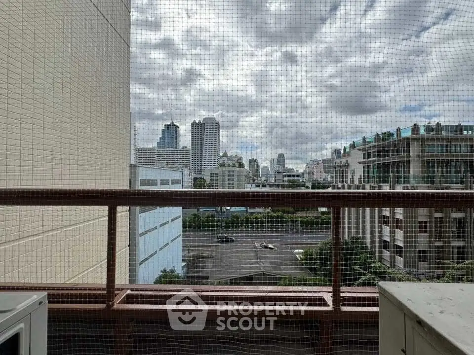 Stunning cityscape view from a high-rise balcony with urban skyline.