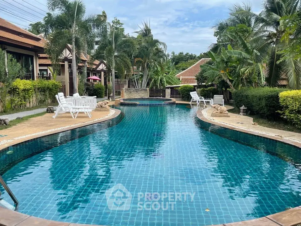 Luxurious tropical pool surrounded by lush greenery and elegant villas, perfect for relaxation and leisure.