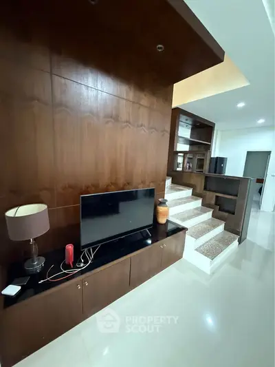 Modern living room with sleek wooden paneling and stylish staircase