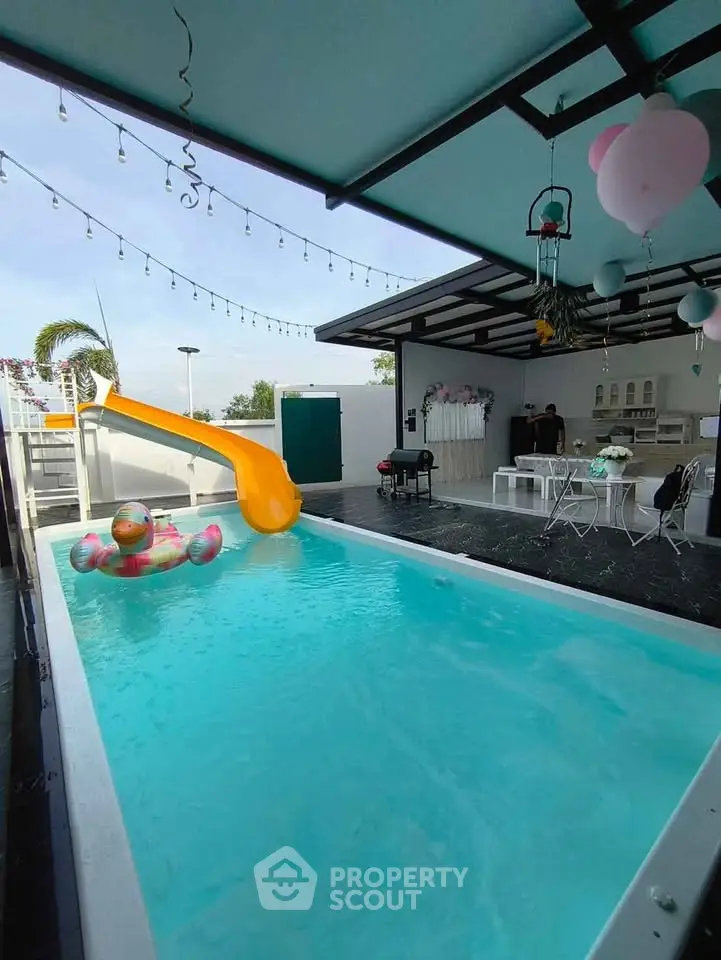 Luxurious private pool with slide and outdoor seating area, perfect for entertaining.