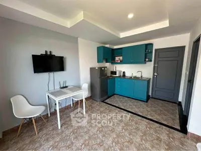 Modern kitchen with teal cabinets and dining area in open layout apartment