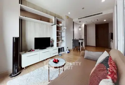Modern living room with stylish decor and open dining area in a cozy apartment.