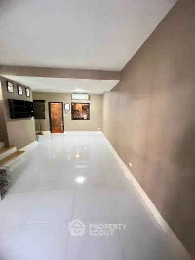 Spacious modern living room with sleek white tiles and neutral walls