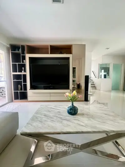 Modern living room with sleek TV unit and marble coffee table, perfect for stylish entertaining.
