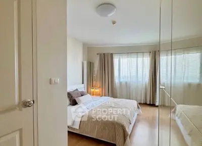 Spacious bedroom with large windows and elegant decor in modern apartment.