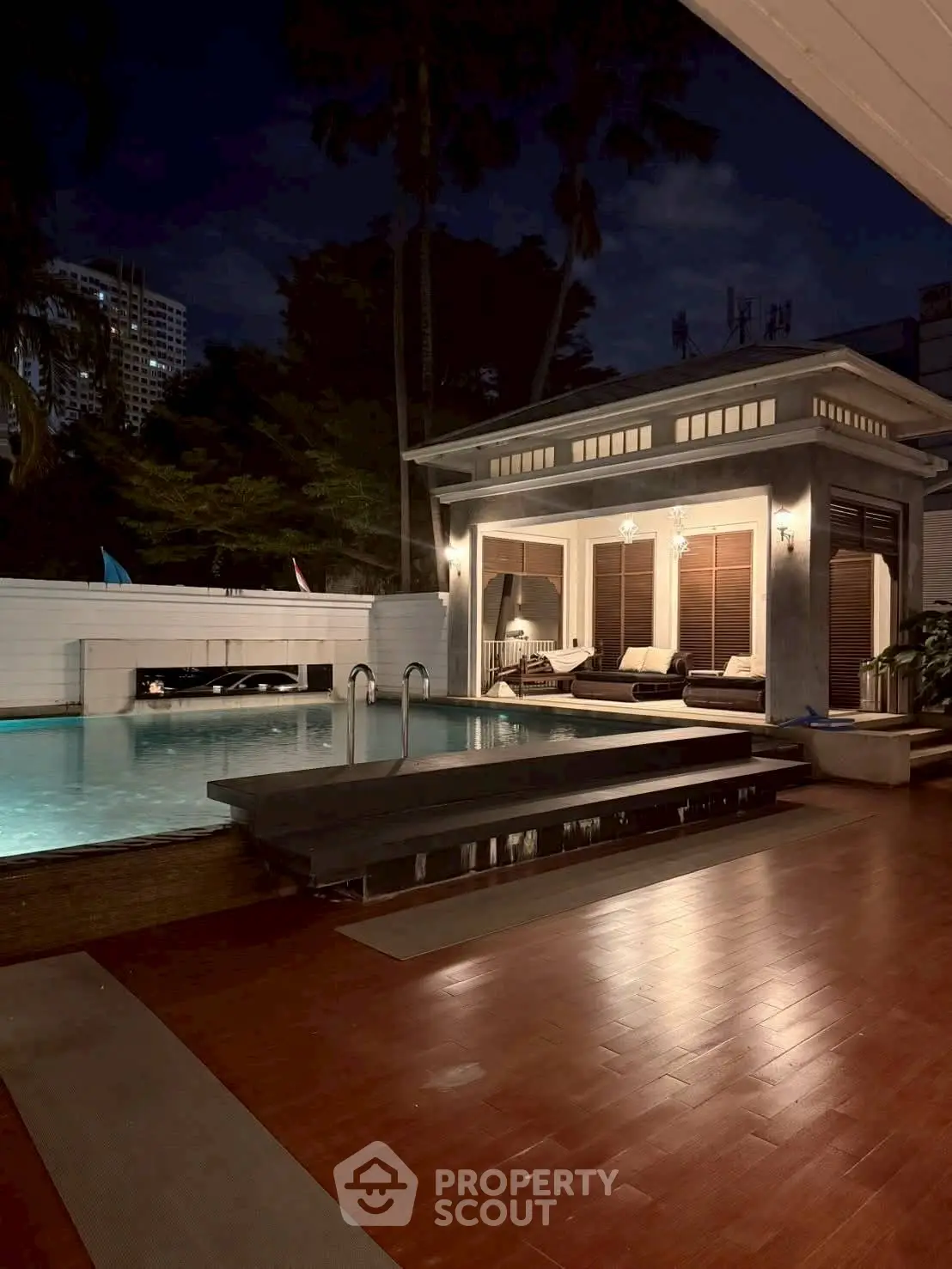 Luxurious poolside view with elegant lighting and modern architecture at night.