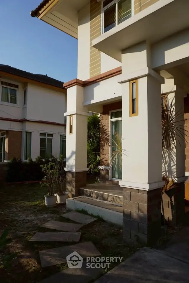 Charming suburban home with inviting entrance and lush greenery