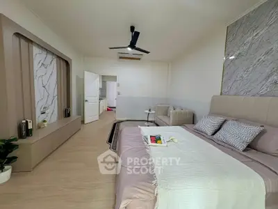 Spacious modern bedroom with elegant decor and cozy seating area