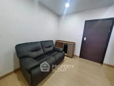 Cozy living room with modern sofa and wooden flooring, perfect for relaxation.