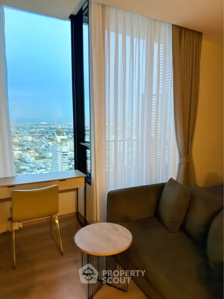Modern living room with stunning city view, featuring a cozy sofa and sleek desk by the window.