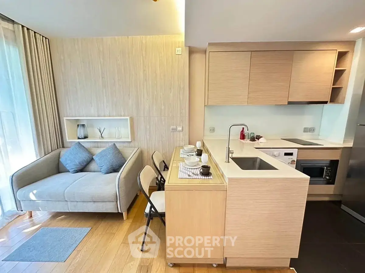 Modern open-layout kitchen and cozy living area with natural light and stylish decor.