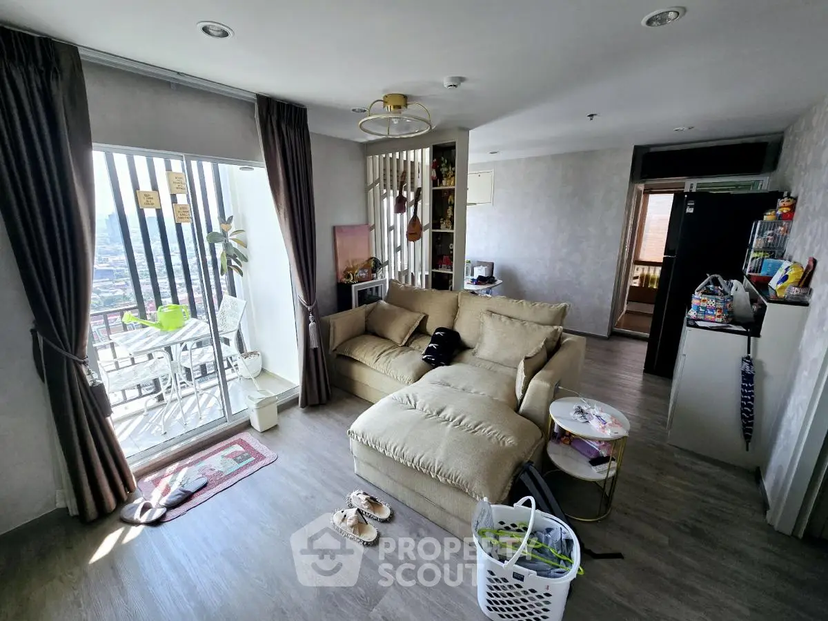 Spacious living room with balcony and modern decor in high-rise apartment