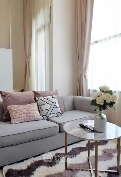 Chic living room with plush sofa, stylish cushions, and elegant curtains, perfect for modern urban living.