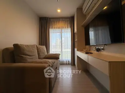 Modern living room with cozy sofa and wall-mounted TV, featuring floor-to-ceiling windows and stylish decor.