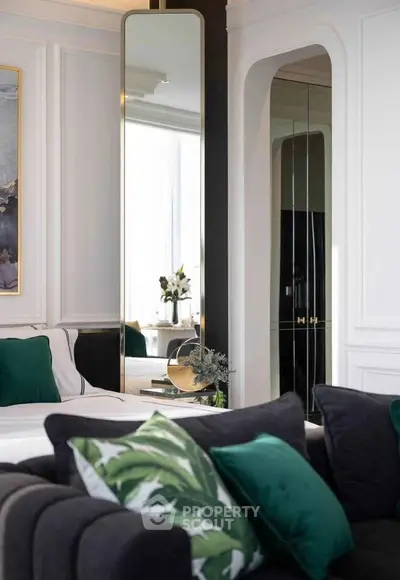 Luxurious living room with elegant decor and large mirror, featuring plush seating and stylish accents.