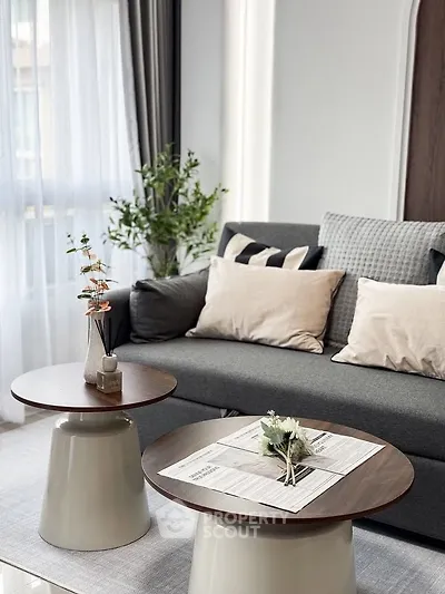 Modern living room with stylish gray sofa and chic coffee tables, perfect for cozy gatherings.