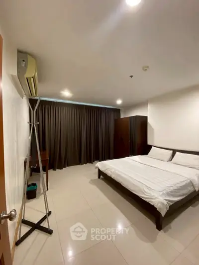 Spacious bedroom with modern furnishings and ample natural light.